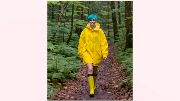 Результат по промпту “Realistic photography. A young woman walks through the forest. She is wearing a yellow raincoat and rubber boots. She has short haircut with bright blue hair. Freckles on the face. She smiles. Natural lighting”. Источник: openart.ai